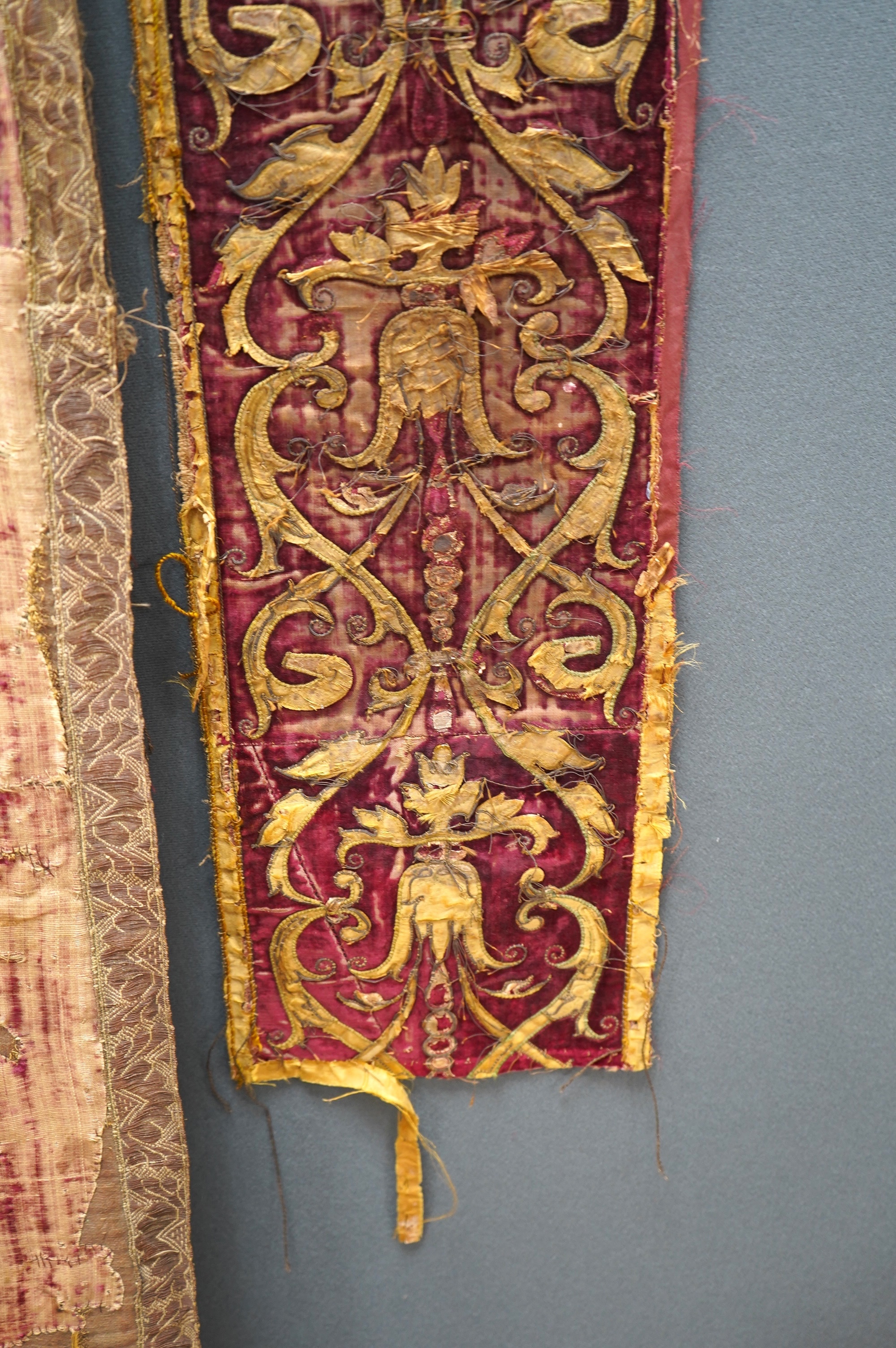 A fine Italian Renaissance style velvet, embroidered and appliqué wall hanging, originally part of a pilaster hanging, made with crimson silk velvet, gold appliqué and colourful polychrome silk embroideries of parrots an